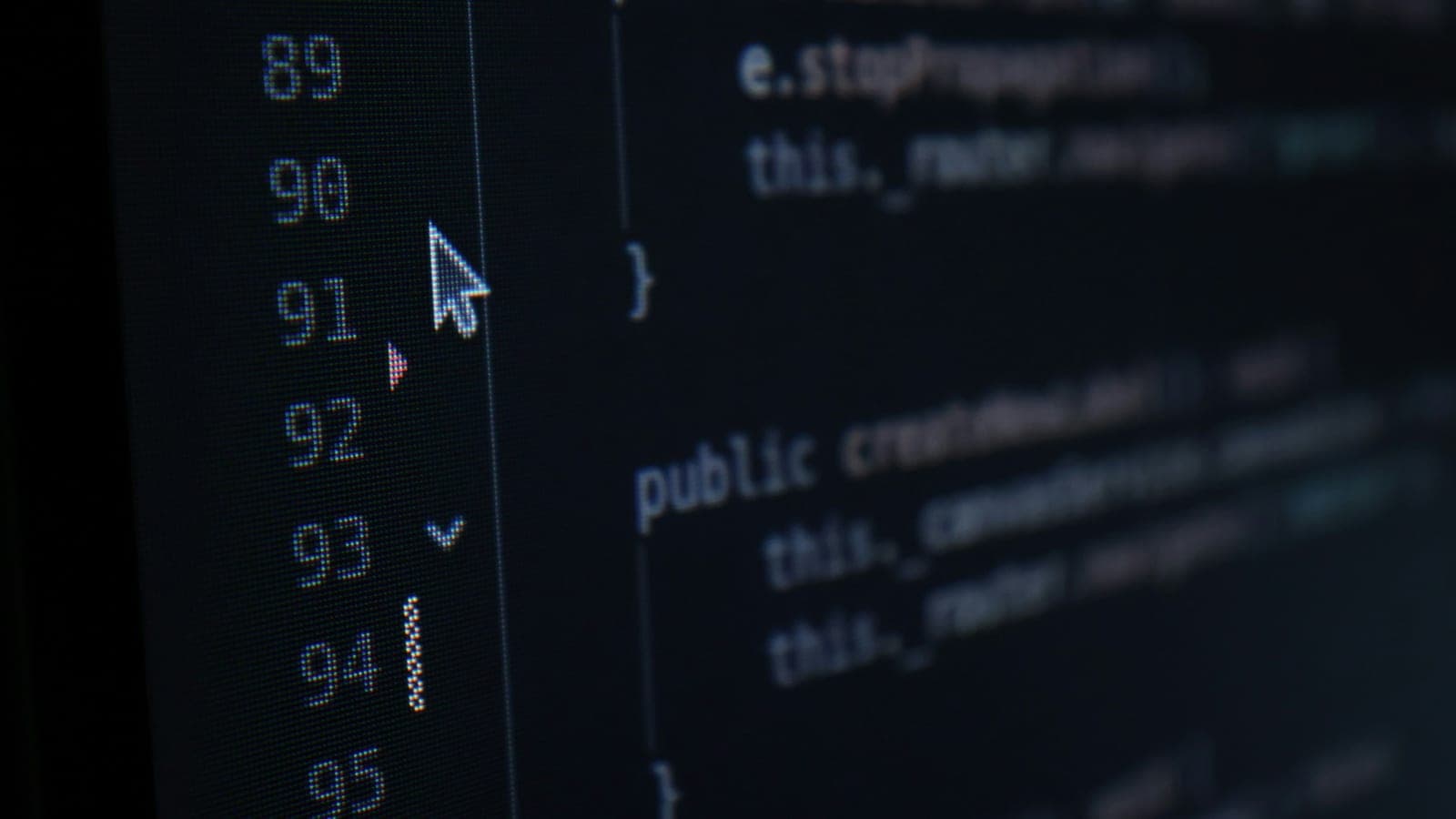 Close-up of code on a dark screen with visible line numbers, deep blue and near-black tones